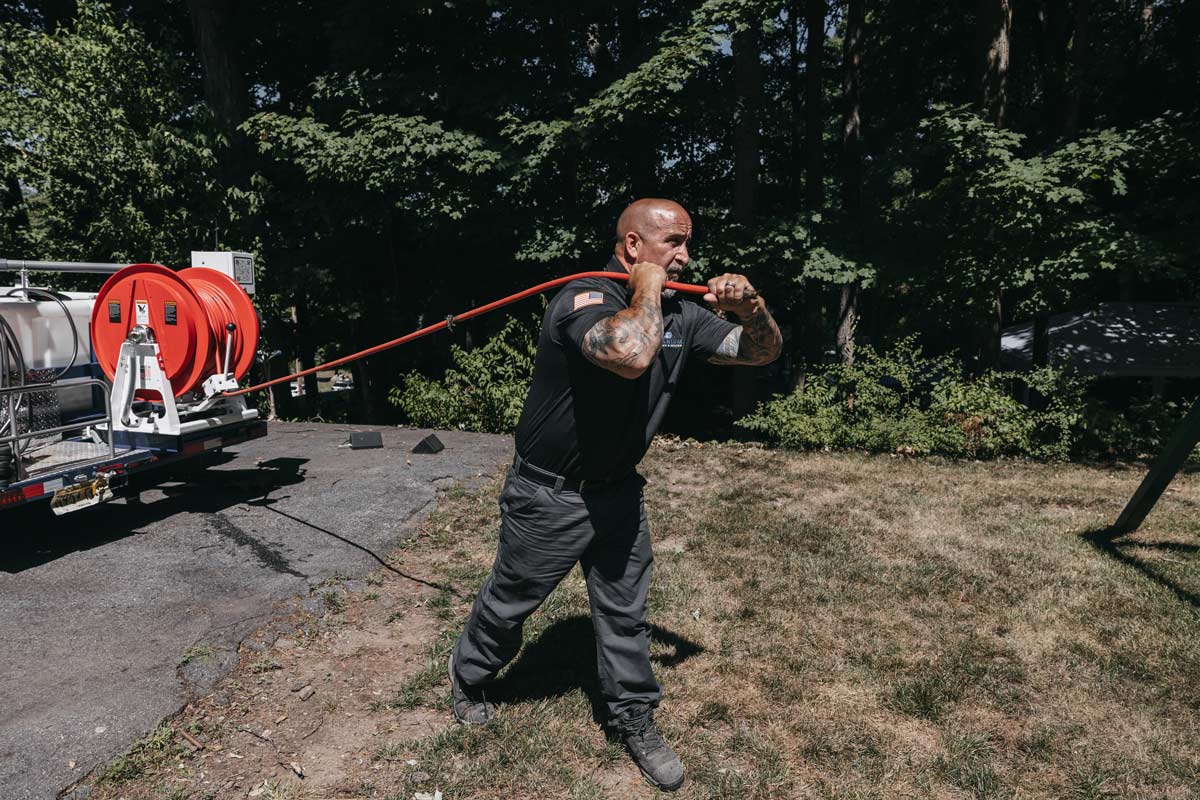 Technician handling a hose connected to a water truck